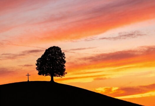 Silhouette of a lone tree and a Christian cross on a hill at sunset, vibrant orange sky and peaceful landscape for religious faith and spiritual contemplation