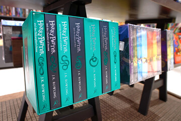 Naklejka premium Minsk, Belarus. Apr 12, 2026. Collection of Harry Potter fantasy novels in special edition boxed sets shown on dark wooden retail display stand. Display of popular fantasy book series by J.K. Rowling