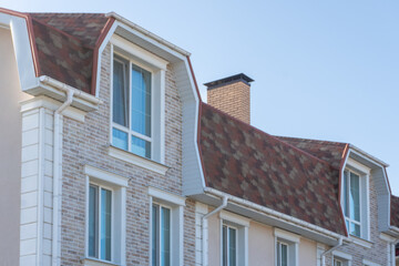 Obraz premium Close-up architectural detail of modern brick townhouse facade with dormer windows