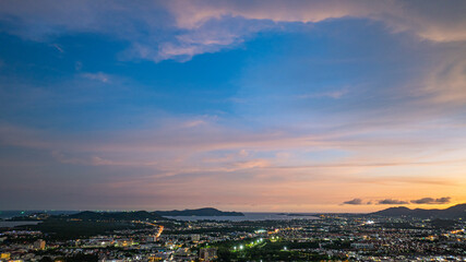 Fototapeta premium Aerial view of Khao Rang Viewpoint at dusk an important landmark in Phuket Town Khao Rang Viewpoint offers a panoramic view and the twinkling lights of Phuket Town at night, which are beautiful.