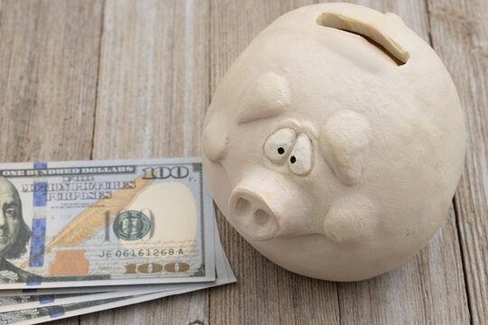 Worried piggy bank with cash and damage