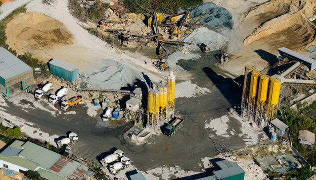 Quarry machinery in cement plant, organizing aggregate stockpiles of sand and gravel in aerial site