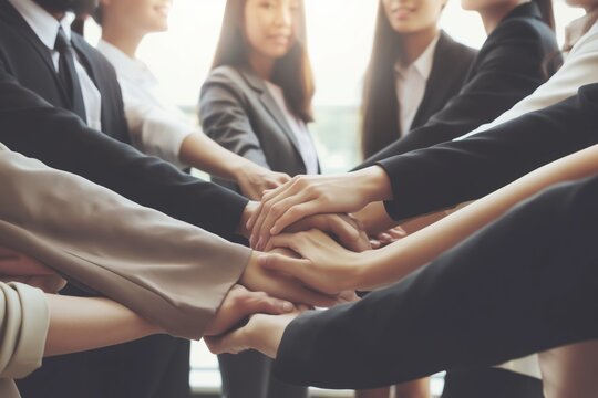 Business team stacking hands together symbolizing unity teamwork collaboration trust and strong corporate culture