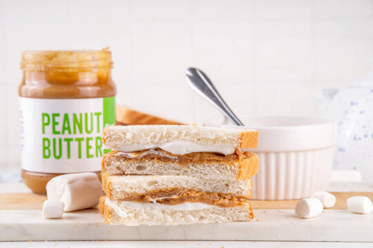 Peanut Butter Fluffernutter Sandwich with fluff liquid Marshmallow paste, Peanut Butter spread, toasted bread. Tasty american breakfast or lunch snack food
