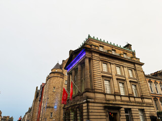 Naklejka premium Historic stone The Inn On The Mile building with classical columns and turret on a city street in Edinburgh, Scotland, UK