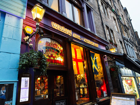 Whiski bar and restaurant exterior with stained glass and flags on the historic Royal Mile in Edinburgh, Scotland UK