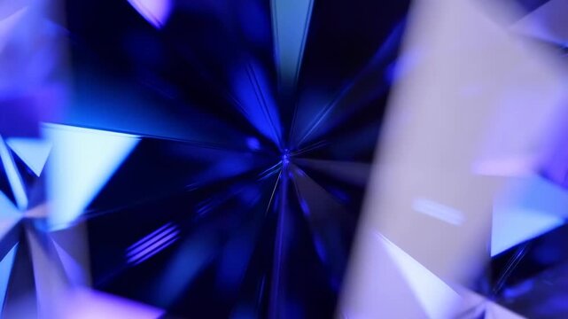 Slow motion macro zoom of blue crystal facets rotating and reflecting under studio lights in close up abstract gem study