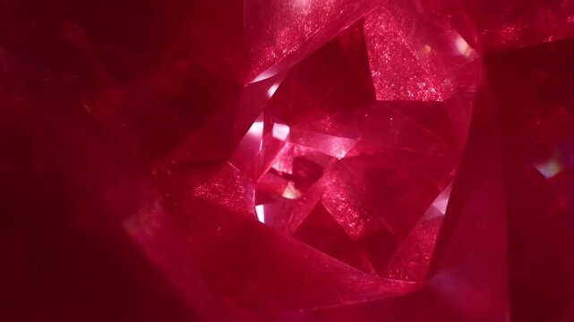 Slow dolly tracking shot of red crystal facets rotating and gliding inside geode cavity with prismatic reflections and translucent gemstone structure close interior