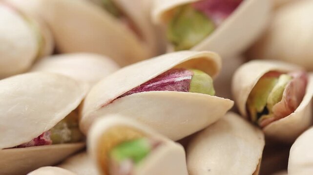 Pile of roasted pistachios in shells rotating slowly. Close-up shot