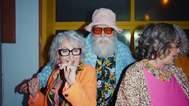 Group of happy senior friends with fancy clothing having party in the night	