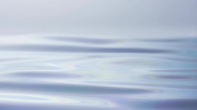 Slow motion close up of calm water surface with gentle ripples and reflective light on open sea horizon in soft morning