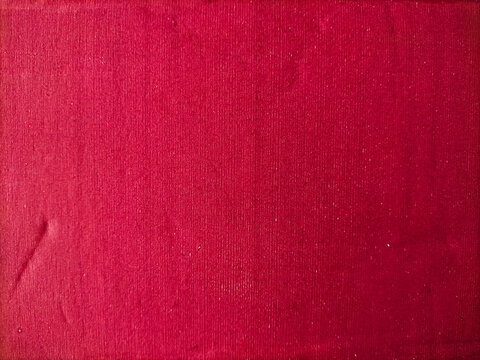 Close-up of a red cardboard surface displaying a deep, rich shade. The texture is characterized by vertical lines, giving it a distinct, tactile appearance.
