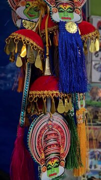 Traditional Kerala ornaments, like this Kathakali Nettipattam, feature iconic green-faced masks, ornate gold-detailed headdresses, & red velvet with blue tassels, blending folk art & cultural heritage