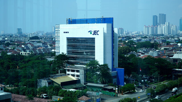 Wide angle view of JEC Eye Hospital building surrounded by trees and urban city neighborhood on April 18, 2026 in West Jakarta, Indonesia.