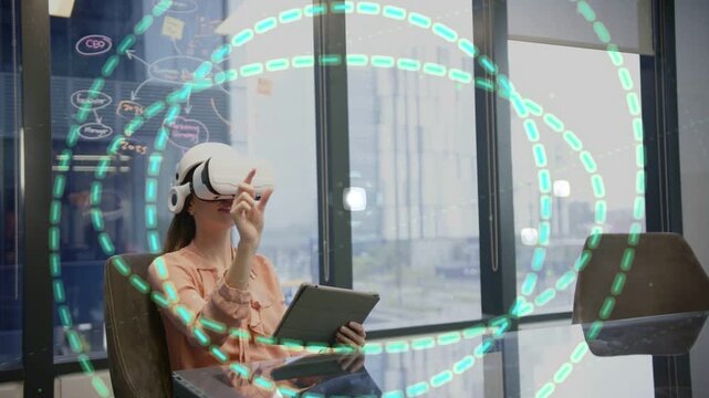 Woman pointing to activate teal rings at glass table, manipulating data for tech demo