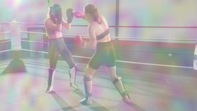 Women fighters training boxing ring, right fighter starting kicks, animating arcs, coach observing