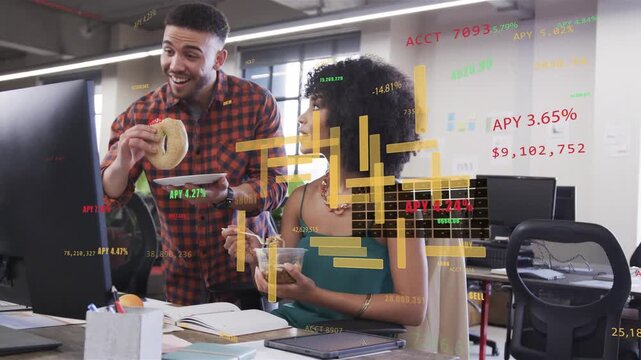 Man showing bagel to seated woman pointing at screen finance charts reacting as pair analyzing data