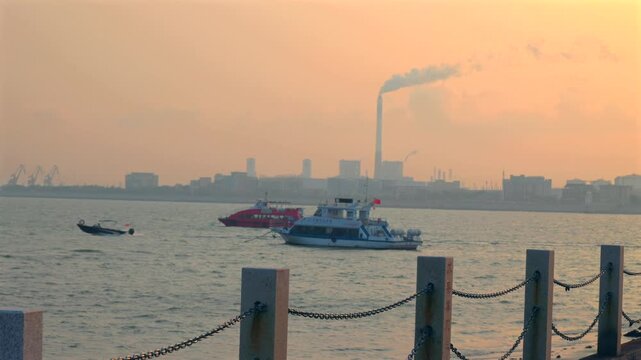 Coastal city skyline with small red tourist boat floating on blue sea under calm atmosphere 4K.serene coastal vacation scene, featuring a red and white excursion boat anchored in the ocean with modern