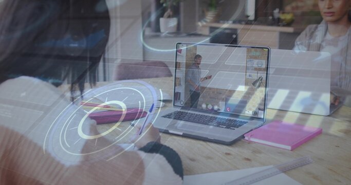 Writing adult taking notes at study table, viewing laptop presenter in collared shirt, HUD overlays