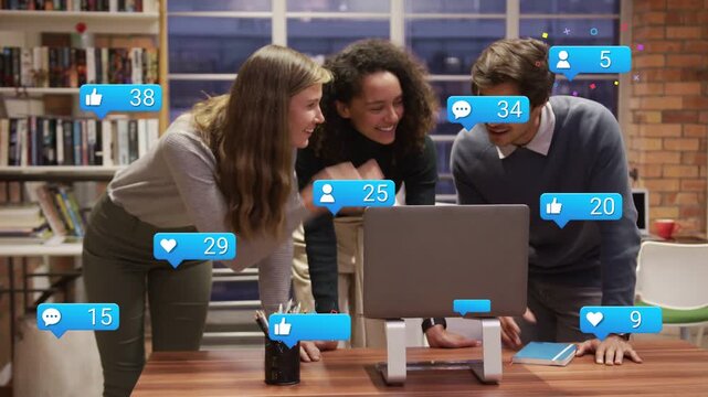 Team leaning over laptop after posting content, watching social media badges growing around screen