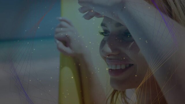 Woman holding yellow surfboard shading eyes from sun scouting waves, travel lines crossing face