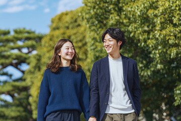 Fototapeta premium Smiling couple strolling in a park with trees, enjoying a sunny day