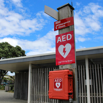 Hot Water Beach, New Zealand - Mar 7, 2026: An AED station, a publicly accessible Automated External Defibrillator designed for emergency use with an emergency phone sign. Editorial Use.