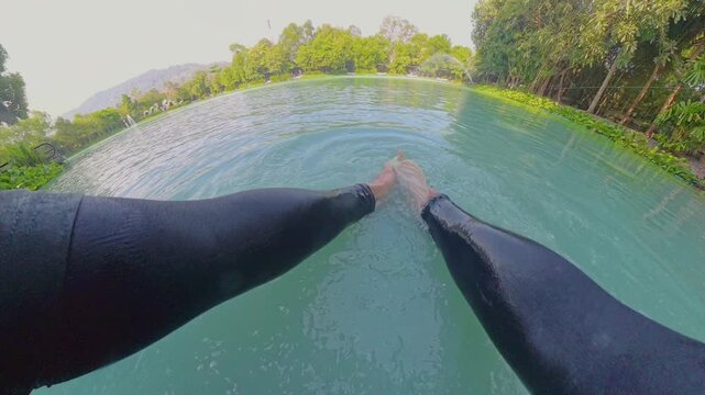 First Person View Releasing Large Alligator Gar Fish Into Clear Pond Water, Hands Letting Go As Fish Swims Away Creating Ripples, Wide Angle Perspective, Outdoor Fishing Scene