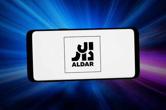 Stuttgart, Germany - 04-13-2026: In this photo illustration, the logo of real estate company Aldar Properties PJSC is displayed on a smartphone in front of abstract background on computer screen.