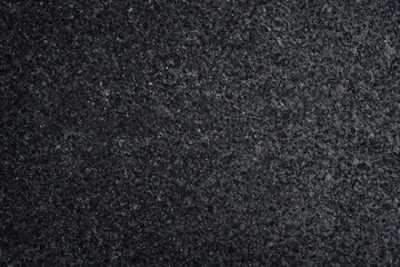 Fototapeta premium Dark asphalt or concrete surface with small stones and rough grain texture. Natural abstract background with subtle variation and industrial feel, suitable for design, overlays and construction themes