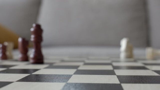 Chess pieces falling and scattered on chessboard after strong wind. Concept of disruption, failed strategy and unexpected challenge.