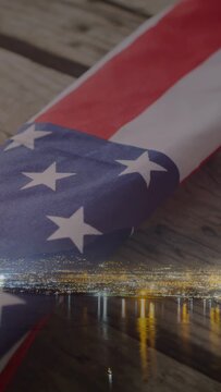 Vertical video: Close crop starting camera pan revealing folded US flag and skyline honoring vets