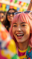 Fototapeta premium Happy young woman with pink hair smiling at a festival. Cheerful female enjoying a summer party with flags behind her