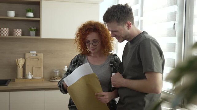 Young couple reading important documents at home