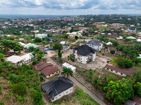 Aerial view of rooftops, trees, and roads create a textured mosaic under a cloudy sky, revealing the serene beauty of the residential area, Asaga, Abia, Nigeria.