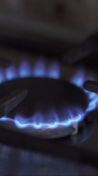 Gas stove being turned on by a lit burner. Natural gas concept.
