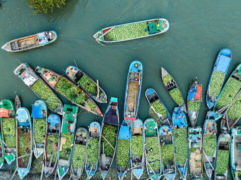 Aerial view of boats laden with produce create a vibrant mosaic of color along the river's edge, Barishal, Barisal Division, Bangladesh.
