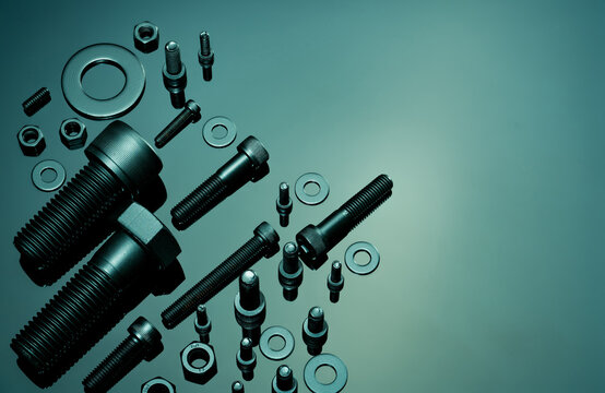 Metal Bolts, nuts, and washers. Fasteners equipment. Hardware tools. Stud bolt, flat washers, hex nuts, and hex head bolts in workshop. Threaded fastener use in automotive engineering. Hexagonal bolt.