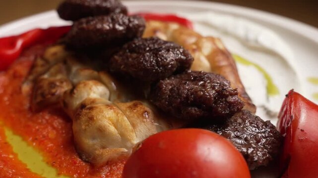 Traditional Turkish meatball dish rotating on a white plate in a restaurant, fa01