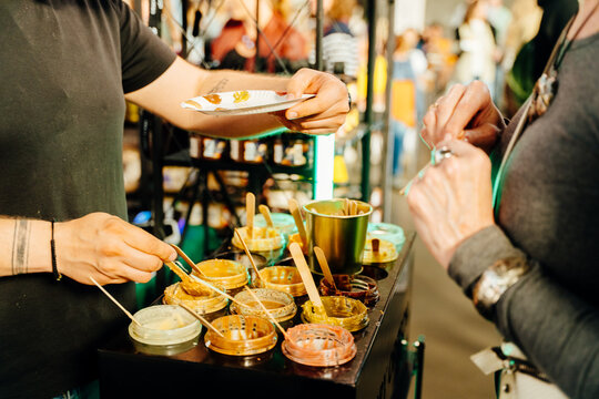 Seller offering peanut butter samples at handmade market stall