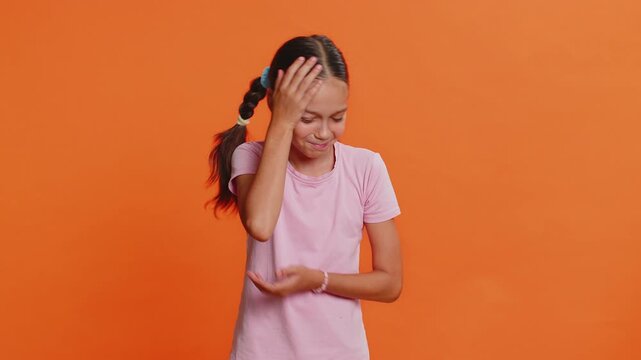Young preteen child girl kid feeling hopelessness and loneliness, nervous breakdown, loses becoming surprised by game fail, bad fortune, loss, unlucky news. Teenager children on orange background