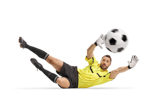Football goalkeeper falling on the ground and trying to save a ball