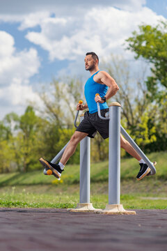 Man exercising on an outdoor leg swing machine