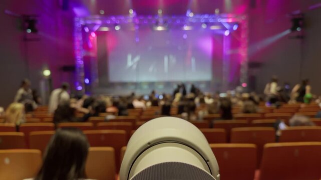 Concert photographer capturing vibrant moments. Dynamic shot of performer under colorful stage lights. Stage focus capturing artist amidst energetic crowd with media coverage