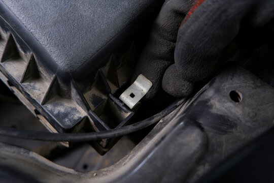 Car Air Filter Housing Clip, A mechanic's gloved hand secures a metal clip on a car's engine air filter housing