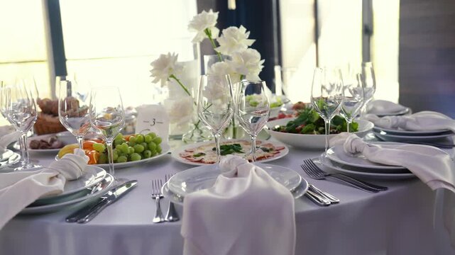 Lots of delicious fresh dishes on the banquet table during a birthday celebration. An event with wine glasses and table settings for the wedding day.