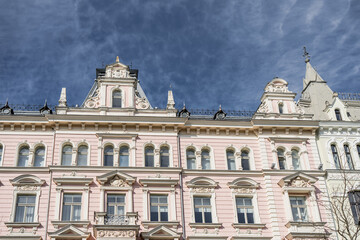 Fototapeta premium Elegant Art Nouveau facade of a historic pink building in Riga Latvia featuring ornate architectural details decorative sculptures and classical window frames