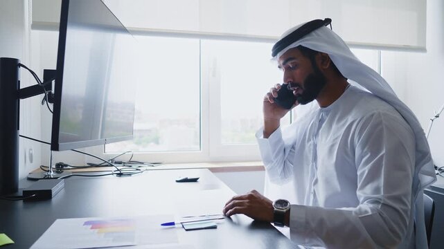 Men with dish dasha working in business office of Dubai. Portraits of successful businessmen in traditional emirates white dress. Concept about middle eastern cultures.
