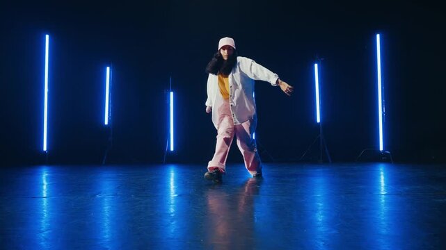 Hip hop dancer dancing in a cool studio with neon lights.
