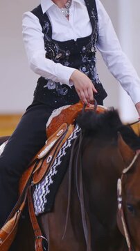 Elegant female horse rider single-handed steering the horse in slow motion 
